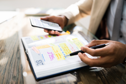 African Man Organizing Appointment Calendar Schedule Using Cellphone