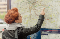 Female tourist looking at big public outdoor street map